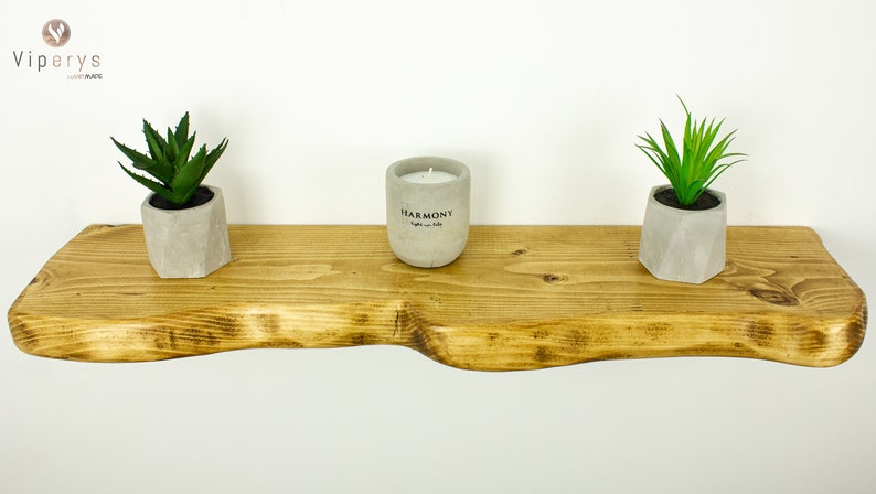 Side view of thick extra live edge rustic shelf highlighting wood texture and natural imperfections. Floating handmade shelf, sustainable solid wood.
Seitenansicht des dicken Wandregals mit sichtbarer Holzstruktur und natürlichen Unregelmäßigkeiten.
Vue latérale de l'étagère épaisse en bois rustique avec détails naturels, artisanat durable.