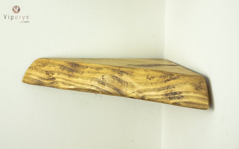 May include: A rustic wooden corner shelf with a natural wood finish. The shelf has a unique, irregular shape and is perfect for adding a touch of farmhouse style to any room.