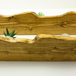 May include: Two rustic wooden shelves with a wavy edge, perfect for displaying small plants or decorative items. The shelves are made of natural wood and have a warm, honey-brown color.