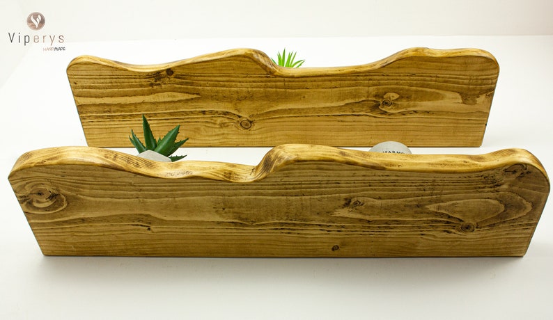 May include: Two rustic wooden shelves with a wavy edge, perfect for displaying small plants or decorative items. The shelves are made of natural wood and have a warm, honey-brown color.