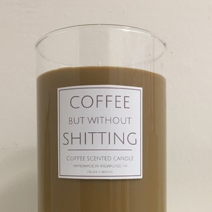 May include: A brown glass candle jar with a white label that reads "Coffee But Without Shitting" and "Coffee Scented Candle Handmade in Milwaukee WI Crude Candles".