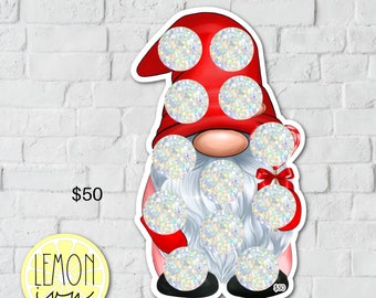 May include: A red and white gnome with a white beard and a candy cane in its hand. The gnome has a red hat with white glitter circles on it. The gnome's beard is covered in white glitter circles.
