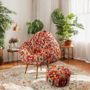 May include: A red, orange, and blue patterned bean bag chair with a matching ottoman. The chair and ottoman are sitting on a patterned rug in a living room setting.