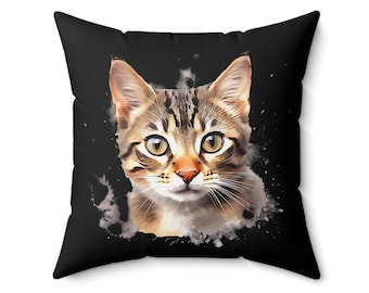 May include: A black throw pillow with a watercolor-style image of a tabby cat's face. The cat has green eyes and a brown and black striped coat.