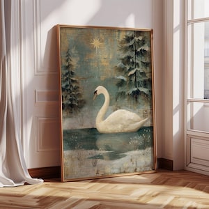 May include: A framed art print featuring a white swan on a lake surrounded by snow and evergreen trees. The artwork has a vintage aesthetic with a gold frame and a teal and gold background. The swan has a curved neck and is floating on the water.