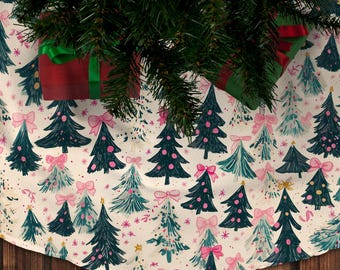 Könnte beinhalten: Ein weißer Christbaumrock mit einem Muster aus grünen und blauen Bäumen mit rosa Schleifen und goldenem Glitzer. Der Rock liegt auf einem Holzboden.