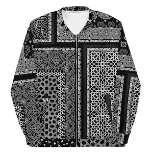 Op de afbeelding: Zwart-wit patroon bomberjack met ritssluiting. De jas heeft een verscheidenheid aan geometrische en bloemmotieven. De tekst "hanikiohanikio" is op de jas gedrukt.