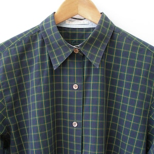 May include: A long-sleeved button-down shirt in a dark blue and green plaid pattern.