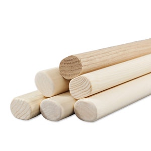 May include: A stack of five wooden dowels, with the top dowel having a slightly different grain pattern than the others.