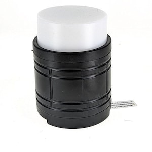 May include: A black cylindrical speaker with a white top. The speaker has a textured design and a warning label on the side.