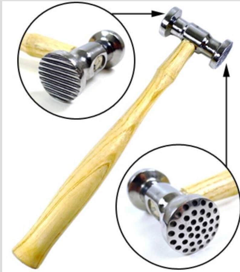 May include: A silver metal hammer with a wooden handle. The hammer has two different heads, one with a textured surface and one with a smooth surface.