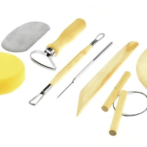 May include: A collection of pottery tools, including a yellow sponge, a loop tool, a needle tool, wooden ribs, a wire cutter, and a wooden knife. The tools are made of wood, metal, and sponge.