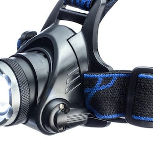 May include: A black headlamp with a blue and black adjustable strap. The headlamp has a white LED light and a silver bezel.