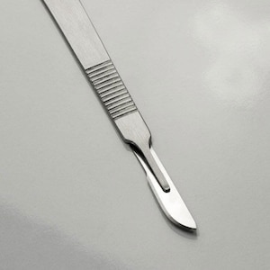 May include: A silver surgical scalpel with a sharp blade.