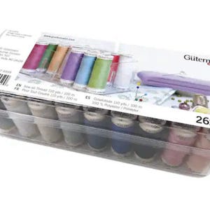 May include: A clear plastic box filled with 26 spools of Gutermann Creative  MCT sewing thread. The spools are arranged in two rows and are in a variety of colors. The box has a label that says "Gutermann Creative MCT 100% Polyester 110 yds / 100 m 26x"