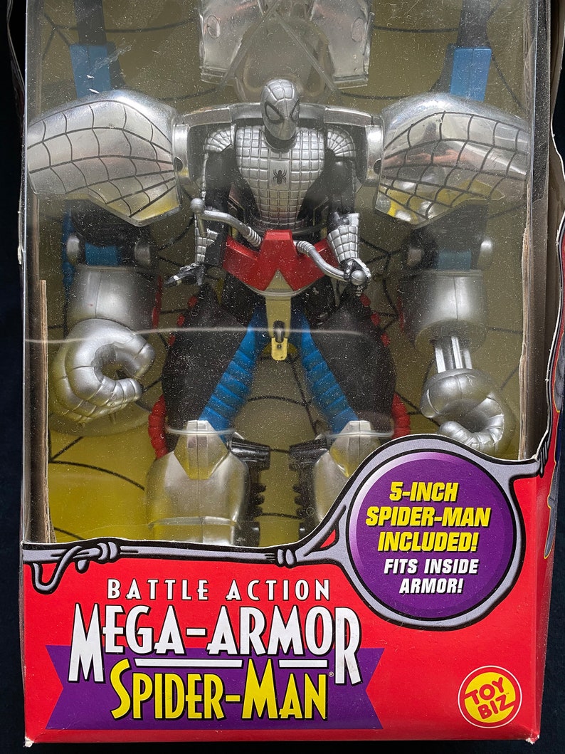Pode incluir: Uma figura de a&ccedil;&atilde;o vermelha, branca e azul do Homem-Aranha com um traje prateado e preto, vestindo uma armadura prateada e preta. A embalagem diz "Battle Action Mega-Armor Spider-Man" e "5-inch Spider-Man Included! Fits inside armor!"