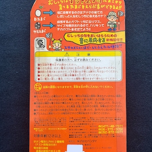 May include: A red and white cardboard box with a picture of a cartoon character holding a net. The box is for a toy called "Oicch! Kett 2" and features the text "What kind of egg will you choose?" and "Grow your own egg!" The box also includes a warning label and instructions for use.