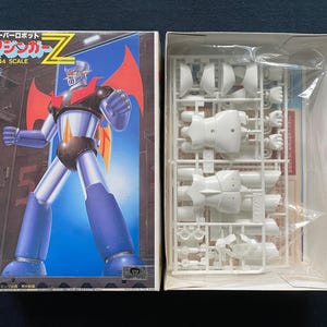 May include: A white ceramic mug with a black handle and the text "But First, Coffee" in a handwritten style. The mug is on a white surface. The mug is 4 inches tall.