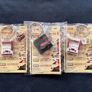 Puede incluir: Tres llaveros con versiones en miniatura de Nintendo Entertainment System, Family Basic y el Robot. Cada llavero tiene un diseño rojo y blanco con el texto "Nintendo" y "1985" impreso en la parte delantera.
