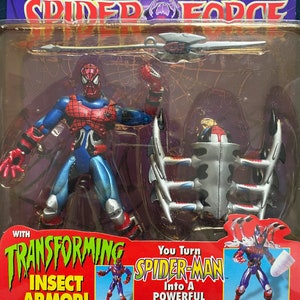 May include: Spider-Man action figure with transforming insect armor. The figure is red and blue with a black spider symbol on the chest. The figure comes with a silver spear and a transforming insect armor that can be attached to the figure. The packaging features the text "You Turn Spider-Man Into A Powerful CyberSpider!"