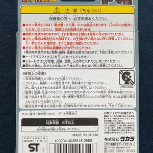 May include: A close-up of a toy horse with a red and white racing saddle. The toy is made of plastic and has a bright, colorful design. The packaging includes a warning label in Japanese, indicating that the toy is for ages 6 and up. The packaging also includes a safety warning about the use of batteries.