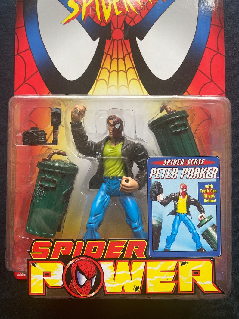 May include: A Spider-Man action figure in a red and black suit with a yellow shirt and blue jeans. The figure is holding a trash can in one hand and a web shooter in the other. The figure is packaged in a plastic blister pack with a red, black, and yellow background. The packaging includes the text "Spider-Sense Peter Parker" and "with Trash Can Attack Action!"