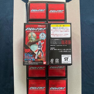 May include: An open cardboard box filled with several red and black toy boxes. Each box features Japanese text and graphics. Some boxes display images of characters. The boxes are stacked inside the cardboard container.