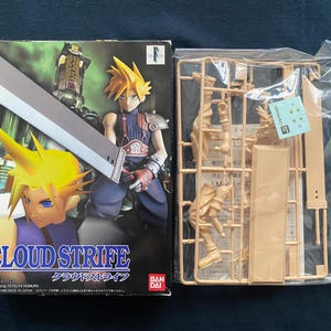 May include: A boxed Cloud Strife model kit with a character illustration on the front. The box features a character with spiky yellow hair holding a large sword. Next to it is a plastic model kit with unassembled parts.