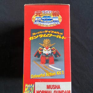 K&ouml;nnte beinhalten: Rote Box mit japanischem Text und einem Bild einer Musha Normal Gundam Figur. Die Box zeigt den Text "Colourful Action Kit!!" und die Figur wird mit zwei Schwertern gezeigt. Box f&uuml;r einen Gundam Modellbausatz.