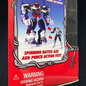 Pode incluir: Uma caixa de cart&atilde;o vermelha e branca com um r&oacute;tulo de advert&ecirc;ncia. A caixa apresenta uma figura de a&ccedil;&atilde;o articulada do Homem-Aranha de 12,7 cm em um traje de Spider-Armor prateado e azul. A figura tem um machado de batalha girat&oacute;rio e um punho de a&ccedil;&atilde;o. O texto na caixa diz "Figura de a&ccedil;&atilde;o articulada do Homem-Aranha de 12,7 cm em Spider-Armor inclu&iacute;da!" e "Machado de batalha girat&oacute;rio e punho de a&ccedil;&atilde;o!"