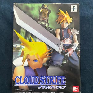 May include: A box featuring Cloud Strife from Final Fantasy VII. The artwork shows Cloud with spiky yellow hair and a large silver sword. The title "CLOUD STRIFE" is displayed, alongside Japanese text and the Bandai logo. The box is dark with a blue background.