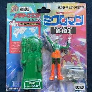 May include: A green and orange plastic action figure of a female robot with a green and white plastic stand. The figure is labelled "Micro Man Lady Command" and "M-183". The packaging is labelled "Micro Man Series" and "Takara サイボーグ研究所".