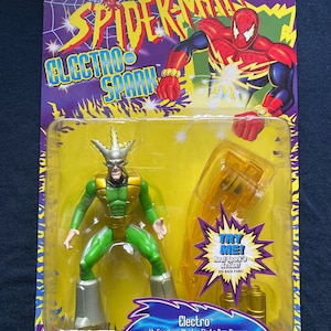 May include: Action figure of Electro from the Spider-Man Electro Spark series. The figure is green and silver with a yellow lightning bolt design. The figure comes with a sparking electro sled and arm cannon. The packaging features a yellow background with a red and blue Spider-Man character.