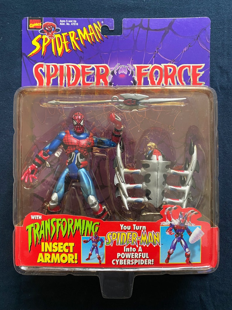 May include: Spider-Man action figure with transforming insect armor. The figure is red and blue with a silver spider symbol on the chest. The figure comes with a silver and black weapon and a separate insect armor piece. The packaging features the text "Spider-Man Spider Force" and "You Turn Spider-Man Into A Powerful CyberSpider!"
