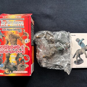 Peut inclure: Une boîte rouge avec une image d'un monstre sur le devant. La boîte est étiquetée "Ray Harryhausen Film Library Real Figure Collection Vol. 5". La boîte contient également une image d'une créature du film "Sinbad et l'œil du tigre".