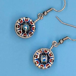 May include: A pair of silver earrings with blue, red, and white mosaic round pendants.