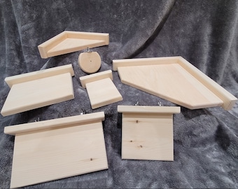 Puede incluir: Siete estantes de madera de diferentes formas y tamaños, hechos de madera natural con un acabado marrón claro. Los estantes tienen una superficie lisa y están diseñados para colgar.