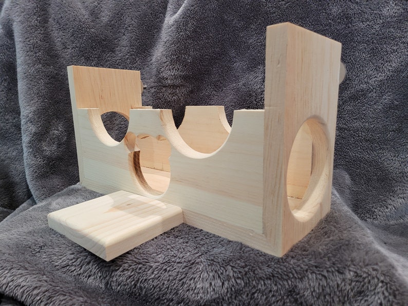 Puede incluir: Estructura de juego de madera para animales peque&ntilde;os, con varios t&uacute;neles y una plataforma. La estructura est&aacute; hecha de madera natural y tiene un color marr&oacute;n claro.