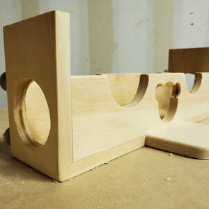 Puede incluir: Un juguete de madera con una variedad de recortes, incluyendo un c&iacute;rculo, un coraz&oacute;n y una forma de oso. El juguete est&aacute; hecho de madera sin terminar y tiene un color natural.