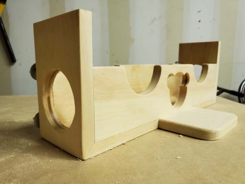 Puede incluir: Un juguete de madera con una variedad de recortes, incluyendo un c&iacute;rculo, un coraz&oacute;n y una forma de oso. El juguete est&aacute; hecho de madera sin terminar y tiene un color natural.