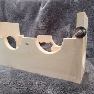 Puede incluir: Una jaula de h&aacute;mster de madera con tres niveles y un recorte en forma de coraz&oacute;n. La jaula est&aacute; hecha de madera natural y tiene dos tornillos de metal en el lateral.