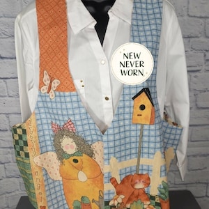 May include: A patchwork vest with a white button-down shirt underneath. The vest features a blue and white checkered pattern, orange straps with butterfly and heart details, and a gardening angel design. A tag reads "NEW NEVER WORN."