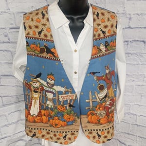 May include: A fall-themed vest with a blue and tan pattern. The vest features scarecrows, pumpkins, and crows. The words "Pumpkin Farm" and "Pumpkin Patch" are visible on the vest. The vest is worn over a white collared shirt.