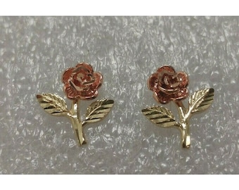 May include: A pair of gold rose earrings with a red rose center. The earrings are made of 14k gold and have a delicate design.