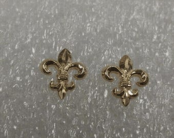 Könnte beinhalten: Ein Paar goldfarbene Fleur-de-lis-Ohrringe.