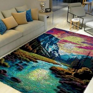 May include: A colorful rug with a landscape scene of mountains, a river, and trees. The rug has a fuzzy texture and is made of a soft material.