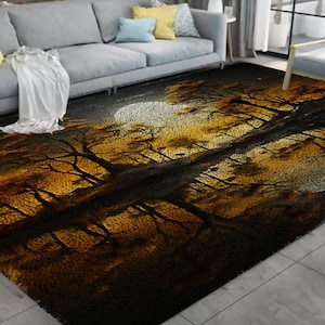 Op de afbeelding: Een zwart en gouden vloerkleed met een ontwerp van bomen en een maan. Het kleed heeft een zachte, pluche textuur.