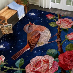 May include: A rectangular area rug with a dark blue background featuring a singing bird perched on a rose branch. The rug has a starry night sky design with pink and red roses. The bird has brown, orange, and white feathers.