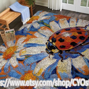 May include: A large, colorful rug featuring a detailed ladybug design. The rug has a blue, orange, and white floral pattern with a prominent ladybug in the center. The ladybug is red with black spots. The rug is a decorative home accent.