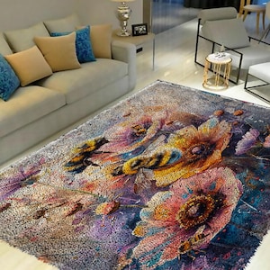 May include: A colorful rug with a floral design featuring bees and flowers in shades of pink, yellow, purple, and blue. The rug has a textured, fuzzy surface.